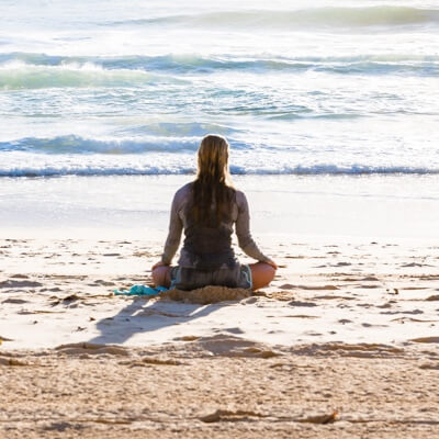 A lady meditating beside beach