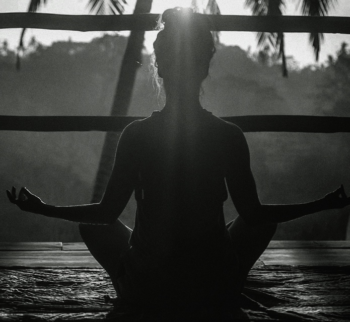 A lady meditating to the sun